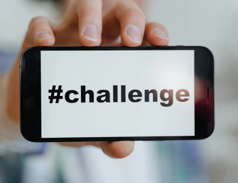 hand holding up a phone with #challenge on the screen