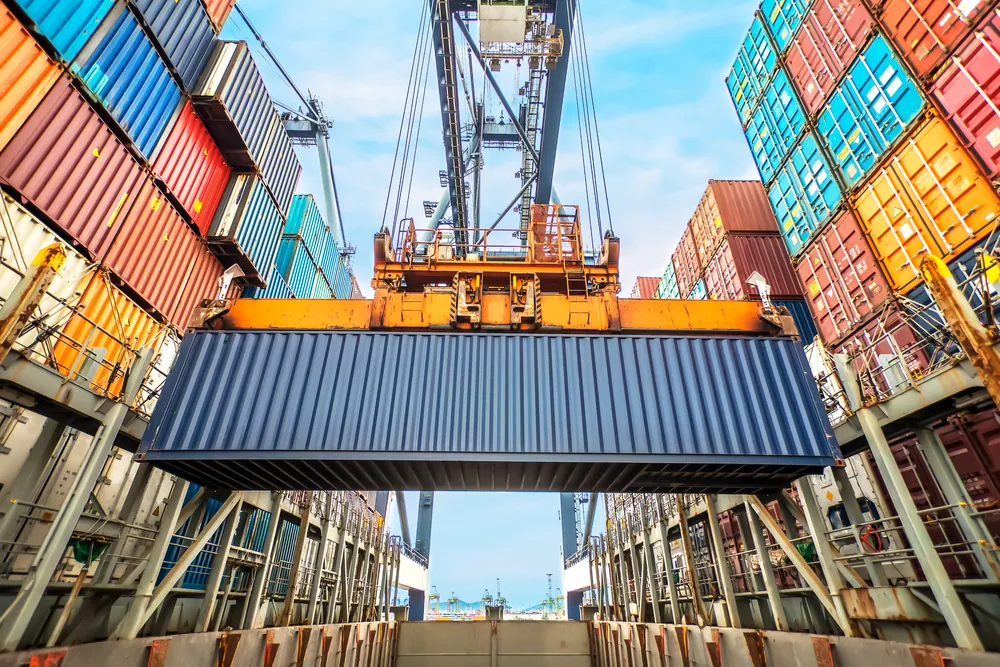 container being being loaded onto a container ship at a seaport