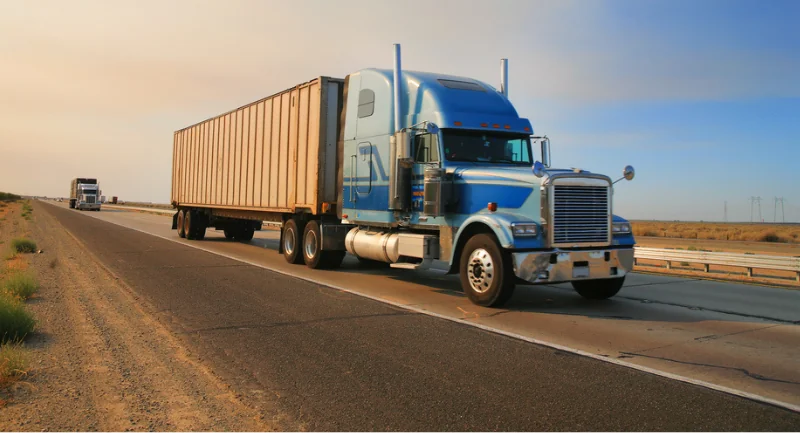 blue semi cab hauling a container